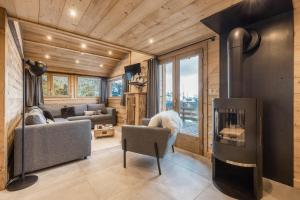 a living room with a fireplace in a house at Chalet Karavi in Manigod