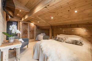 a bedroom in a log cabin with a bed and a table at Chalet Karavi in Manigod
