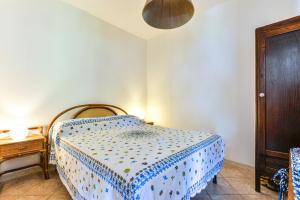 a bedroom with a bed with a blue and white blanket at Casa Vacanze Iosè in Rio Marina