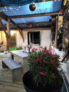 a patio with a table and flowers in a pot at Les dames du pont in Pontgibaud +2 photos