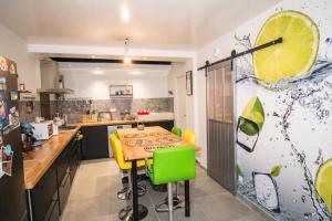 a kitchen with a wooden table and yellow chairs at Les dames du pont in Pontgibaud
