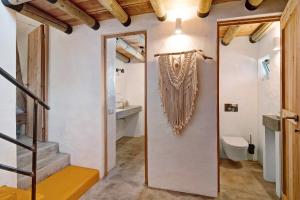 a hallway with a staircase and a bathroom with a toilet at Casa Osga in Moncarapacho +24 photos