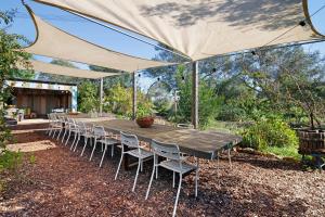 a long table and chairs under a tent at Casa Osga in Moncarapacho