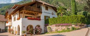 a house with flowers on the side of it at Rosengartnerhof Apt Vorberg in Terlano