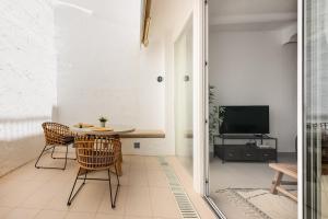 a room with a table and chairs and a television at Vivienda Casares in Estepona