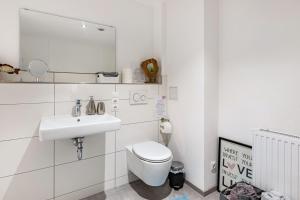a white bathroom with a toilet and a sink at Schmuckstückchen in Hilzingen