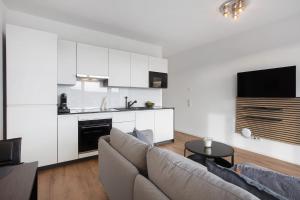 a living room with a couch and a kitchen at Ferienwohnung Panoramablick in Lörrach