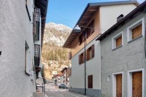 an alley with buildings and a mountain in the background at A Due Passi Valdidentro in Valdidentro