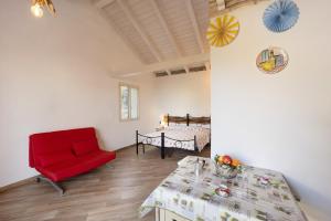 a living room with a red chair and a table at Timo in Pompeiana +18 photos