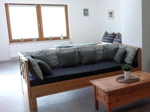 a couch with pillows on it in a living room at Ferienwohnung, offenes Apartment in Mochenwangen