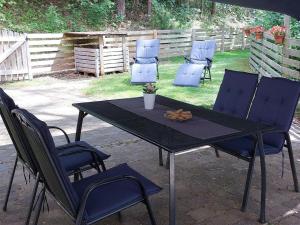 a black table with chairs and a table with a plant on it at Ferienwohnung, offenes Apartment in Mochenwangen +15 photos