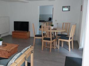 a living room with a table and chairs and a television at Ferienwohnung, offenes Apartment in Mochenwangen