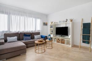 a living room with a couch and a tv at La Chinija in Playa Honda