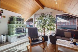 a living room with a green fireplace and a chair at Ferienwohnung Tannhausen in Aulendorf