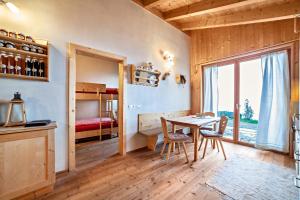 a dining room with a table and chairs and a bedroom at Grushof App Paföl in Sluderno