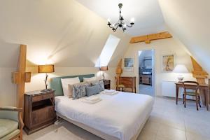 a bedroom with a bed and a desk and a chair at Le Promontoire in Groléjac