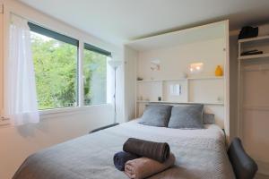 a bedroom with a bed and a large window at L'Annexe du Petit Echo de la mode in Plélo