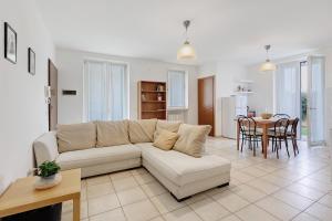 a living room with a white couch and a table at Condo-Micio Luna in Villafranca di Verona