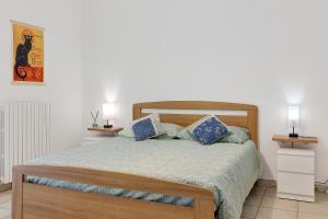 a bedroom with a bed with blue pillows at Condo-Micio Luna in Villafranca di Verona