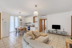 a living room with a couch and a tv and a kitchen at Condo-Micio Luna in Villafranca di Verona +20 photos