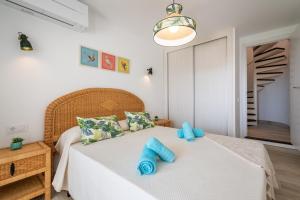 a bedroom with a bed with blue pillows on it at Apartamento Ola de Mar in Felanitx