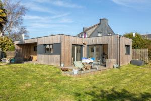 a wooden house with a lawn in front of it at La Cabane in Combrit