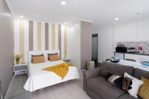 a bedroom with a bed and a couch at 58 Studio in Ribeira Grande