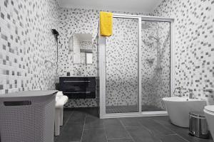 a bathroom with a shower and a toilet and a sink at 58 Studio in Ribeira Grande +17 photos