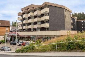a building with cars parked in a parking lot at Heimelig im Hirschen App 118 in Schönwald