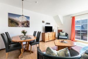 a living room with a table and chairs and a tv at Katharina in Westerdeichstrich