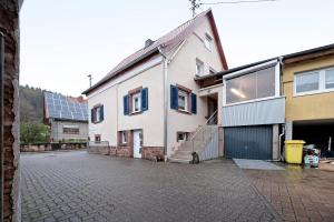 a white house with a staircase next to a street at Wasgauaktiv in Schindhard