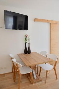 a dining room table with two vases on the wall at Apartment Blaser in Mühlbachl