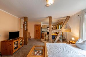 a bedroom with a bed and a living room at Krüseliner Mühle - Ferienwohnungen in Krüselin