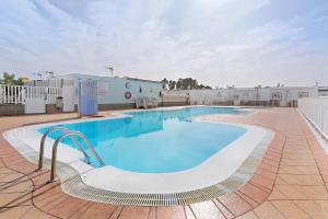 a large swimming pool with a building in the background at Bungalow Aloe Dunas 2 in Maspalomas