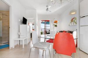 a living room with a table and a red chair at Bungalow Aloe Dunas 2 in Maspalomas