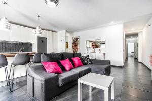 a living room with a gray couch and pink pillows at Bright in Agaete