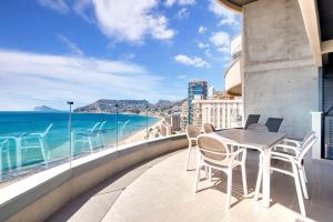 a table and chairs on a balcony with a view of the beach at Infinium 12b in Calpe