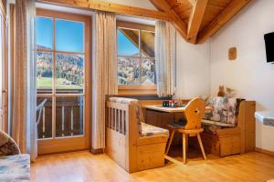 a living room with a desk and a large window at Apartments Campagnola in Badia