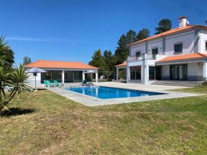 a villa with a swimming pool in front of a house at Quinta Vale do Tejo in Chamusca