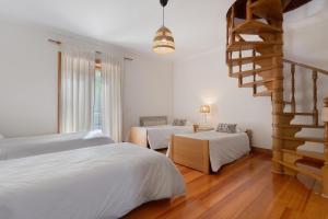 a bedroom with two beds and a spiral staircase at Quinta Vale do Tejo in Chamusca +37 photos