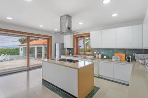 a kitchen with white cabinets and a large window at Quinta Vale do Tejo in Chamusca