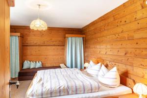 a bedroom with a bed and a wooden wall at Anni in Leutasch