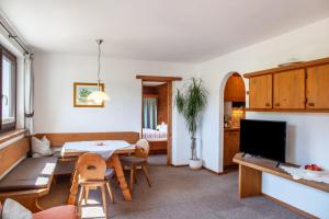 a living room with a table and chairs and a television at Anni in Leutasch