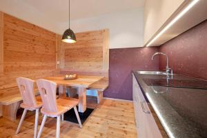 a kitchen with a table and chairs and a sink at Teutenhofer Zwetschge in Feldthurns