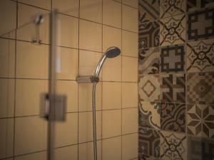 a shower with a shower head in a bathroom at Casa na Vila T2 in Fuzeta +6 photos