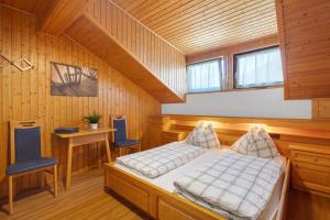a bedroom with a bed and a table and chairs at Pension Waldheim Rooms in San Giacomo