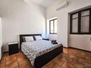 a bedroom with a bed and a window at Casa na Vila T2 in Fuzeta