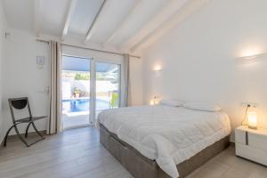 a white bedroom with a bed and a balcony at Bennu in Calpe +28 photos