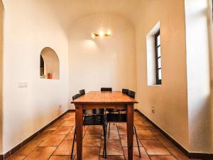 a wooden table with chairs in a room at Casa na Vila T2 in Fuzeta