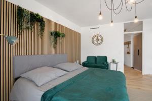 a bedroom with a large bed and a green chair at Global Bnb - Loft 28 Green in Augsburg